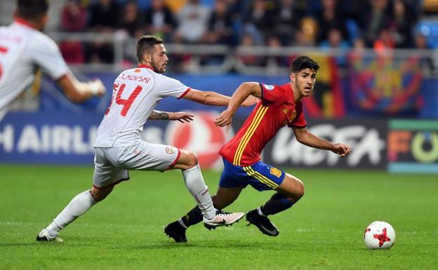 Marco Asensio (d) se escapa de un rival durante el España-Macedonia. /AFP