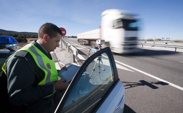 Un Guardia Civil controla un radar móvil en una carretera.