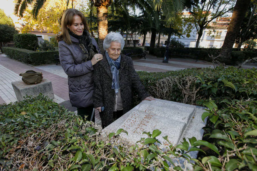 La nieta pequeña, María José Canales, con su madre, Leandra Corrales, nuera de Antonio Canales, junto al bloque de piedra en forma de libro que recuerda al alcalde en la plaza que lleva su nombre. 