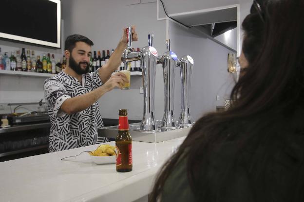 Un camarero sirve una cerveza en un bar de Mérida. :: j. m. romero/