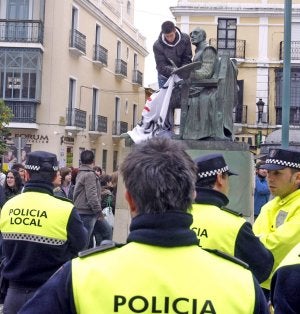Un estudiante coloca la pancarta ante la Policía Local. :: ALFONSO/