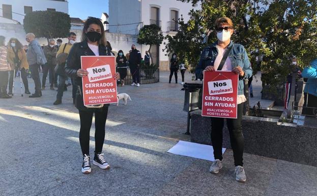 Dos asistentes a la concentración sujetan carteles de protesta/Lydia Sánchez