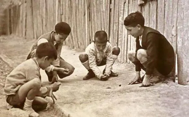 Niños jugando a los bolindres.