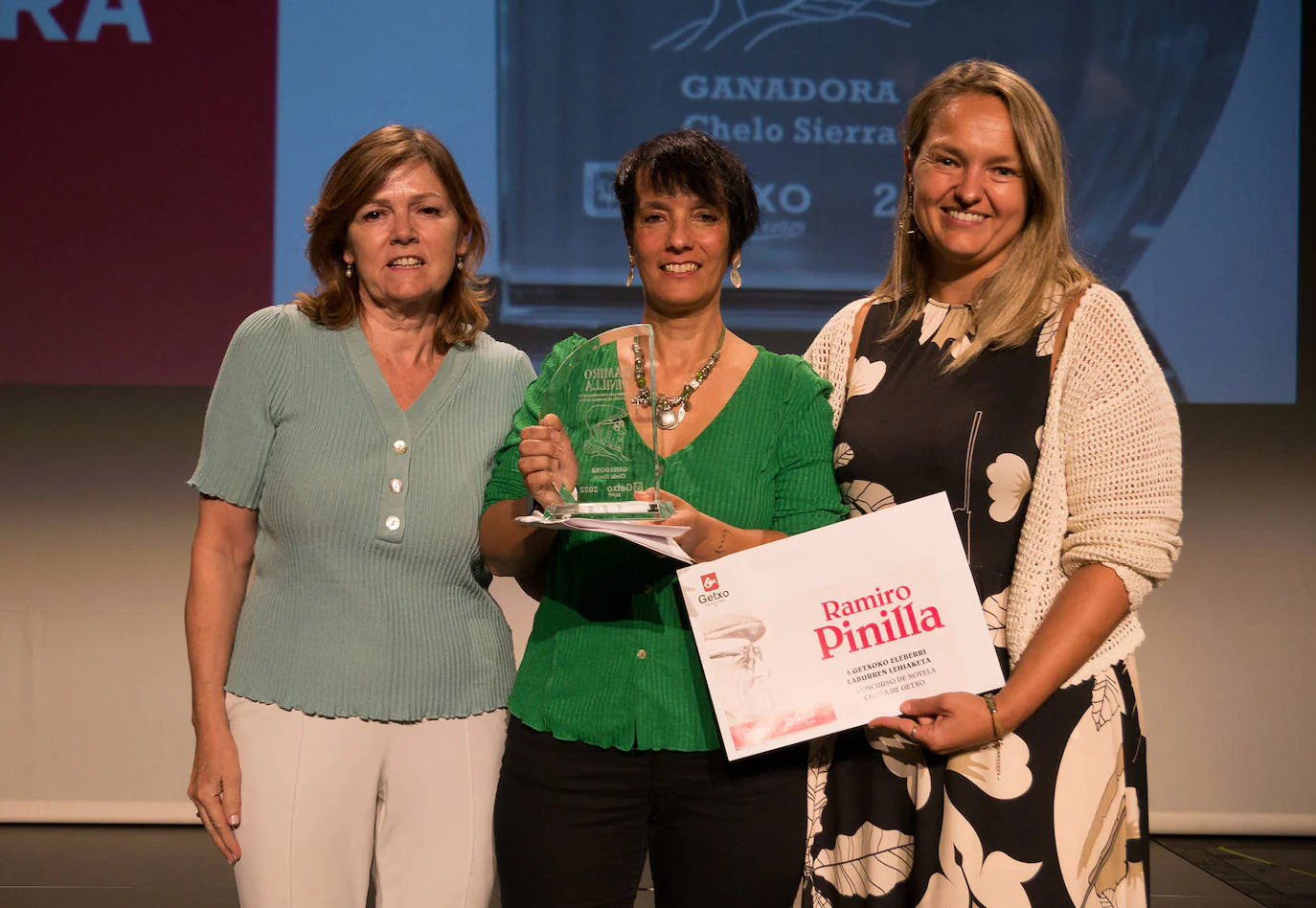 Chelo Sierra, en el centro, recibe el galardón a la mejor novela escrita en castellano.