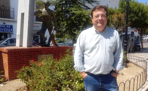 Fernández Vara posa ante una figura en honor los agricultores de Ricardo García Lozano, escultor de Villanueva de la Serena. /JUAN MIGUEL MÉNDEZ PEÑA