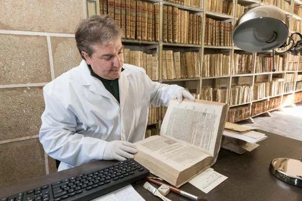 Gorka Díaz inspecciona uno de los cerca de 5.000 volúmenes de entre los siglos XVI y XVIII que se conservan en la biblioteca. :: andy solé/