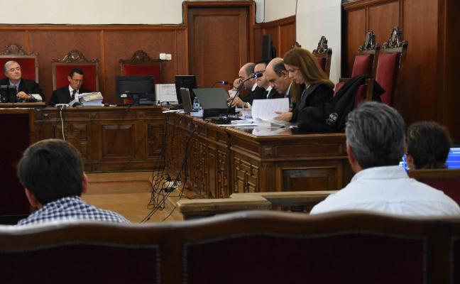 Los acusados, de espaldas, durante la primera sesión del juicio que comenzó ayer. :: c. moreno/