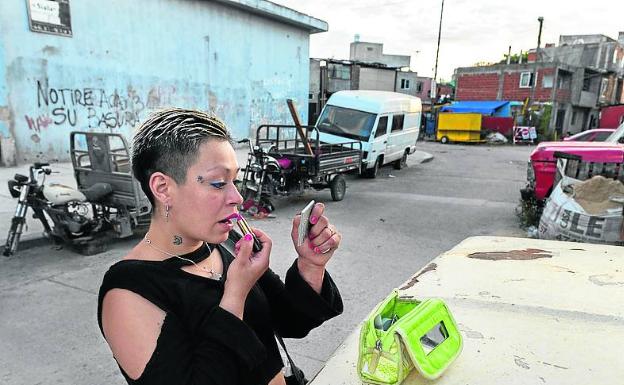 Una mujer se pinta en un barrio pobre de Buenos Aires.