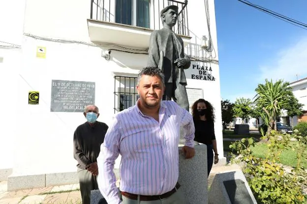 Antonio Morillo, junto a dos vecinos de Valdelacalzada y al monumento que honra a los colonos que fundaron este pueblo de las Vegas Bajas. / BRÍGIDO