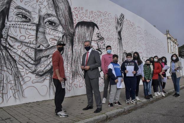 El Chino, ante el mural a los docentes presentado esta semana. / C. MORENO