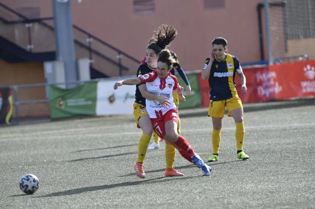 Alba Mellado intenta marcharse con el balón ante la oposición de una jugadora del Deportivo. / J. V. ARNELAS