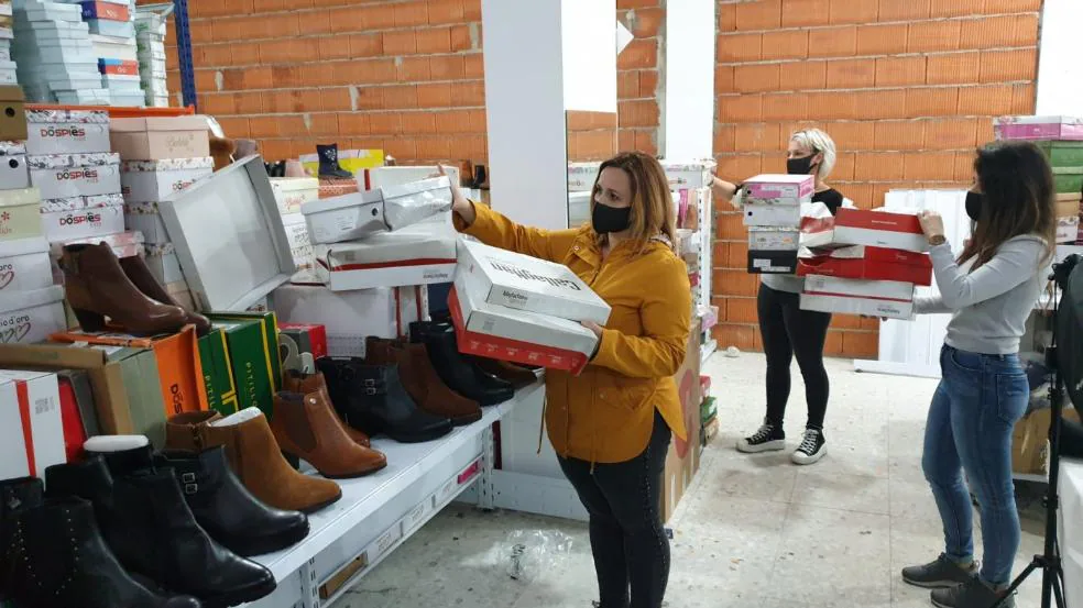 En Calzados Gallego sacan los zapatos de las cajas mojadas para que se sequen. / S. GÓMEZ