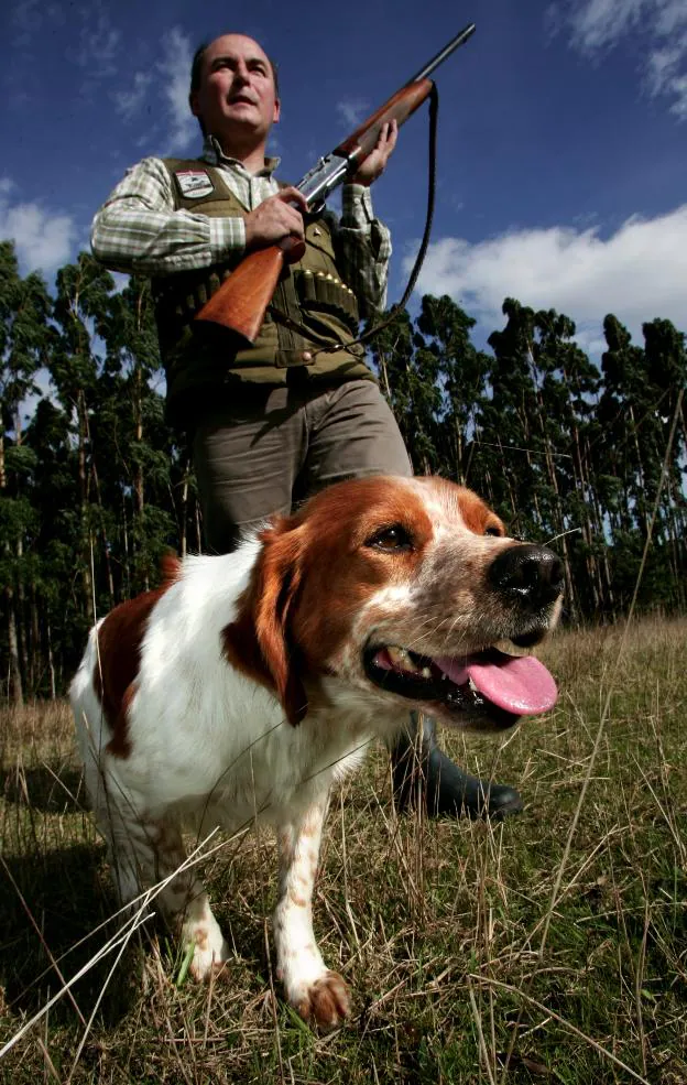 Un cazador armado de escopeta y acompañado por su perro. / HOY