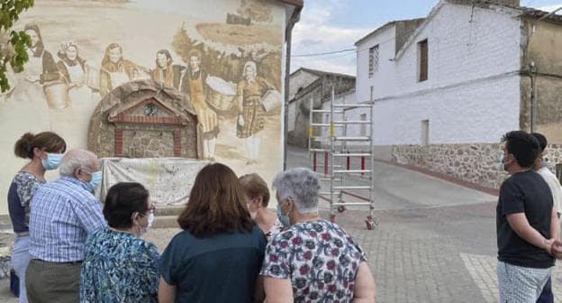 Vecinos frente al mural durante su realización. / O. F.