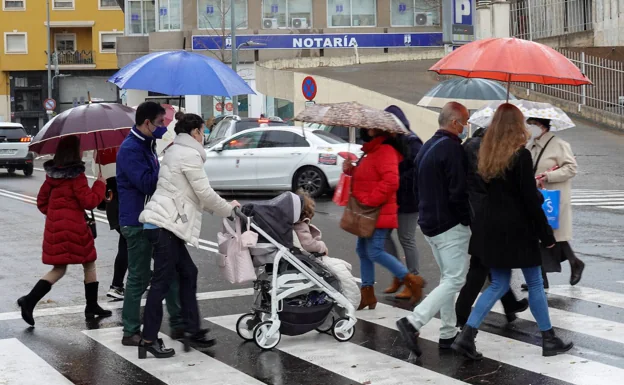 Ciudadanos con paraguas en Badajoz este martes. /CASIMIRO