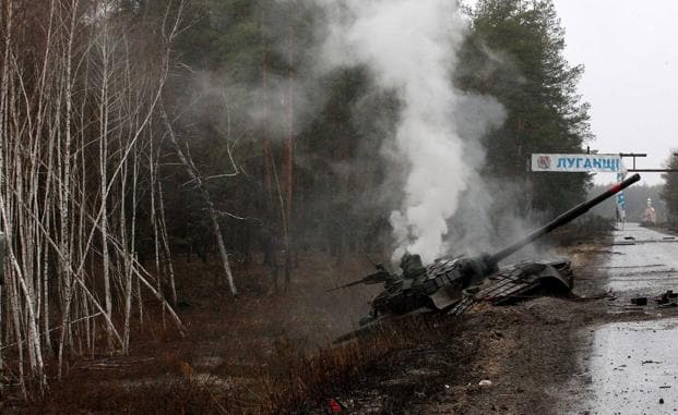 Un tanque ruso desprende humo tras ser destrozados por las tropas ucranianas en una carretera de Lugansk. /afp