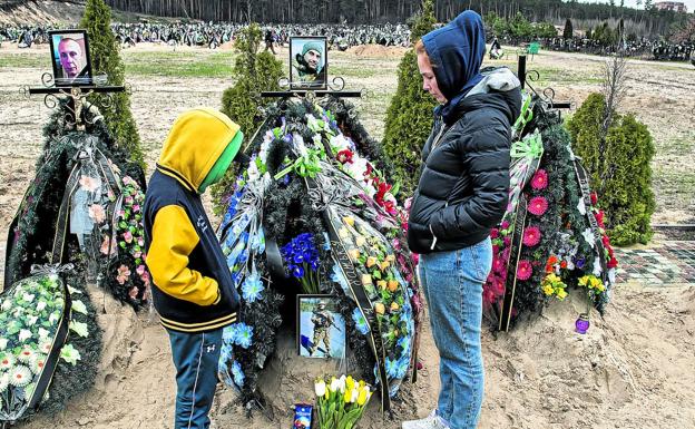 Alla Krotkikh y su hijo Savely Krotkikh, ante la tumba de su padre./Zigor Aldama