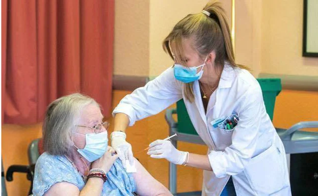 Una enfermera vacuna a una anciana contra el covid. 