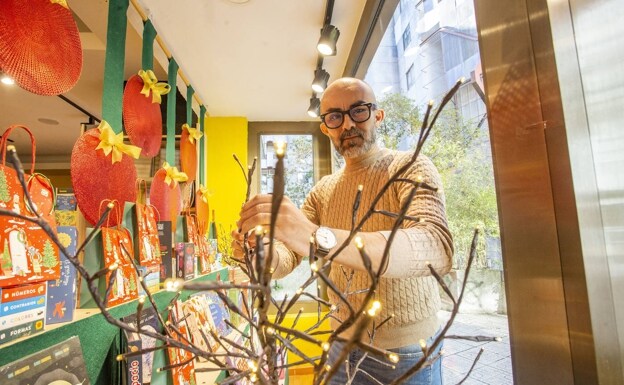 El decorador rayano José Antonio Piris durante la preparación del escaparate navideño de la librería Nobel, en la Plaza de los Maestros. /JORGE REY