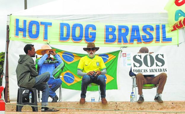 Varios bolsonaristas se concentran ante un cuartel militar de Brasilia exigiendo la intervención del Ejército para evitar la investidura de Lula./Adriano Machado/reuters